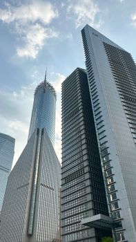 View of modern skyscrapers in Shanghai, featuring sleek architecture and a blue sky backdrop.