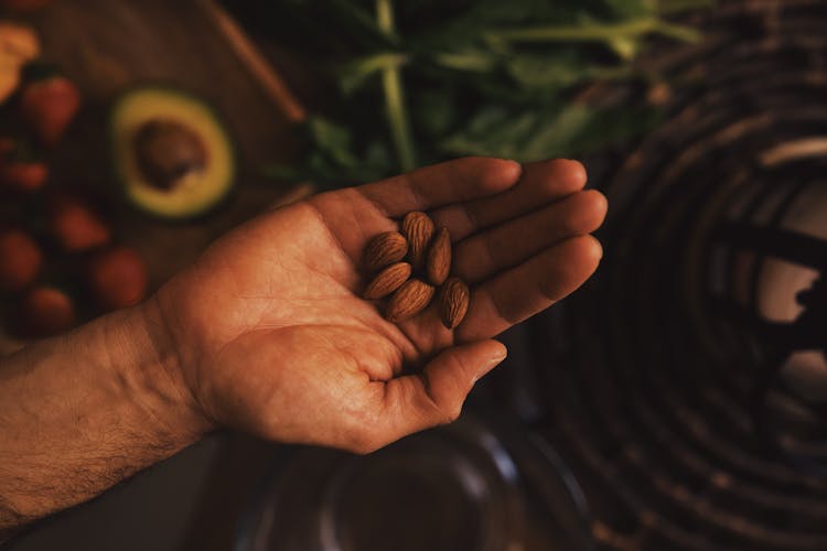 Crop Person Holding Handful Of Raw Almonds