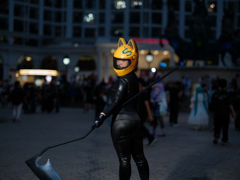 A cosplayer with a yellow helmet stands out at a vibrant night event in Việt Nam.