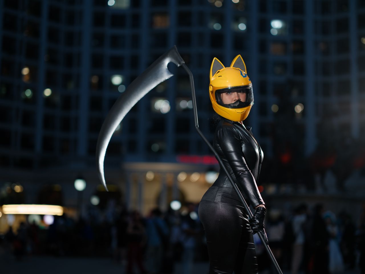 cosplayer in vietnam wearing black suit with yellow helmet holding scy