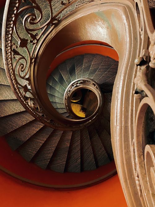 Free Artistic spiral staircase with intricate railing in Ho Chi Minh City, captured with warm golden tones. Stock Photo