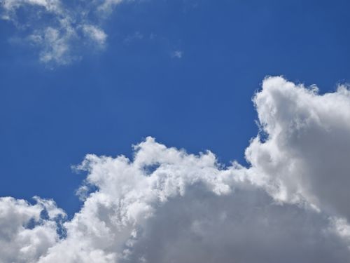 Free Capture of a bright blue sky filled with fluffy, white cumulus clouds. Stock Photo