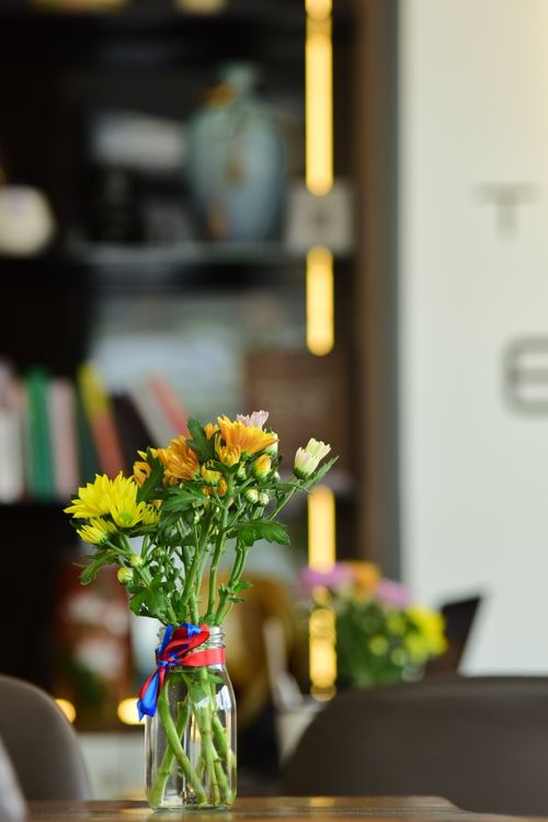 Free A colorful bouquet of flowers in a jar adds charm to a cozy indoor cafe environment. Stock Photo