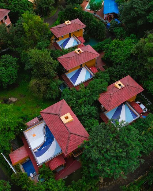 Free Vibrant aerial shot of red-roofed houses surrounded by greenery in Mumbai, India, showcasing architectural layout. Stock Photo