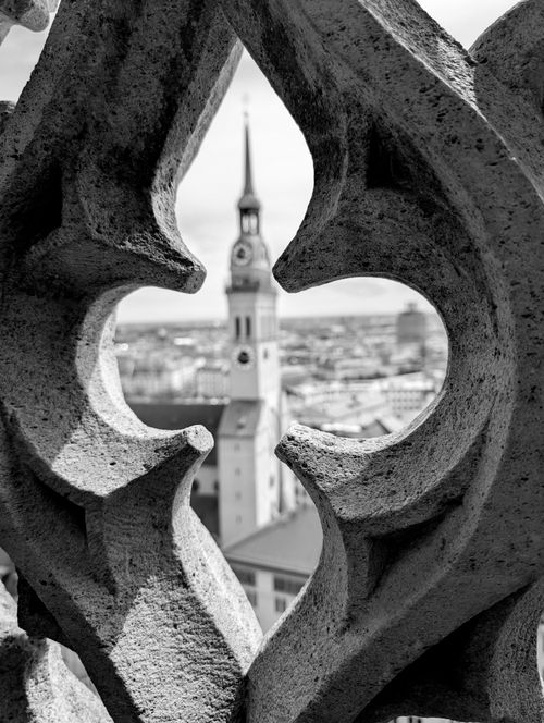 Free Black-and-white view of a historic church tower framed by intricate Gothic architecture in Munich. Stock Photo