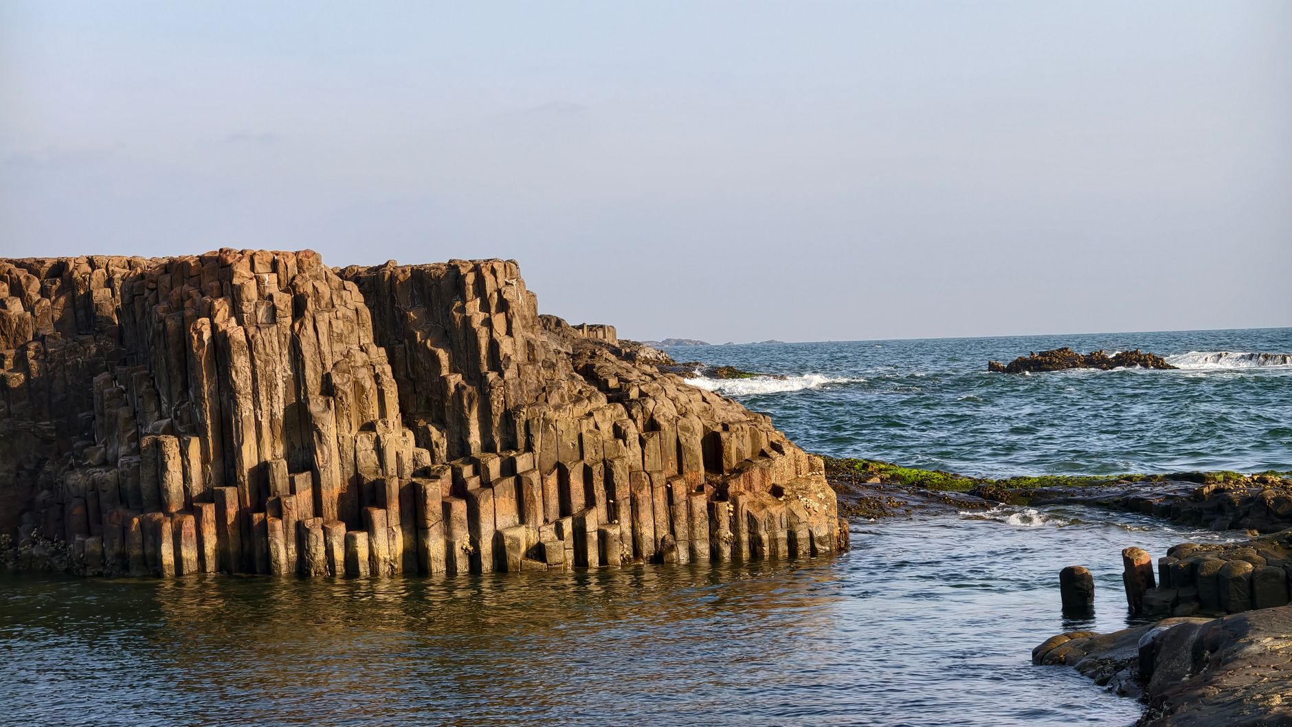 Faraglioni dei Ciclopi basalt sea stacks rising from the water at Aci Trezza, fishing boats in foreground