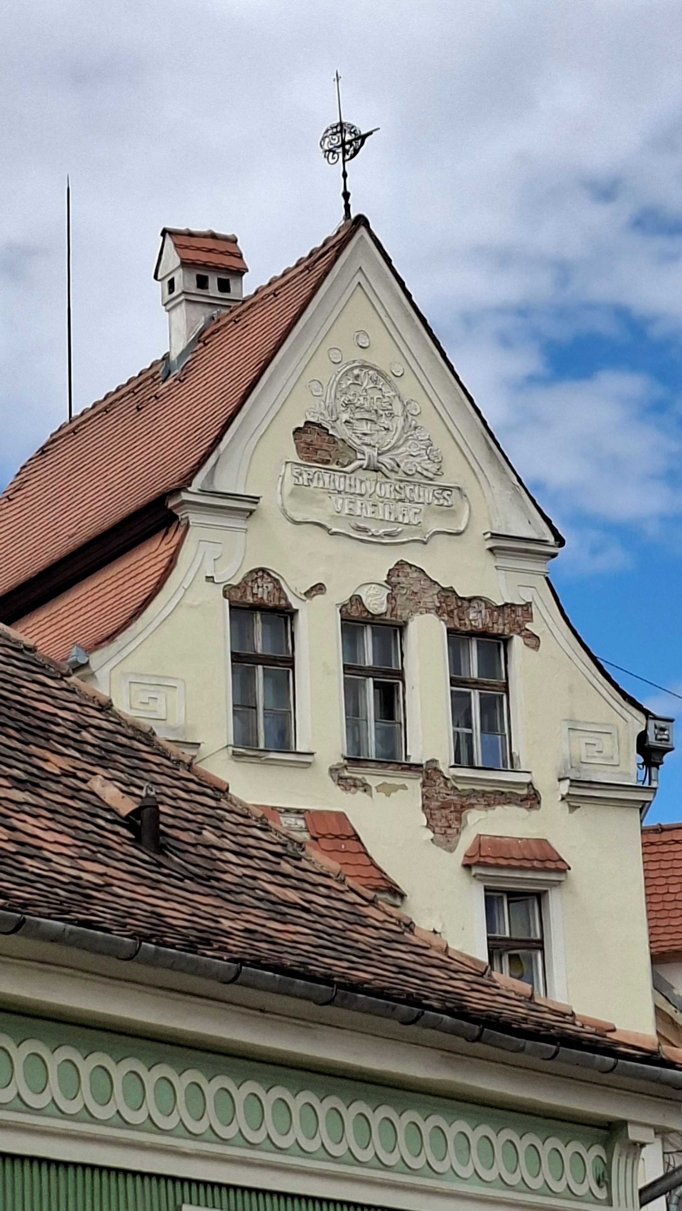 Close-up view of a historic European building's roof with ornate details under a clear sky.