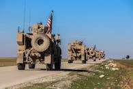 在叙利亚农村，美国军事车队驶过蓝天之下