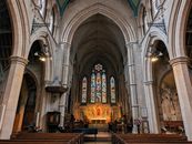 Beautiful view of All Saints Church's interior with stained glass windows and arches in London.