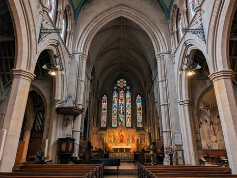 Beautiful view of All Saints Church's interior with stained glass windows and arches in London.