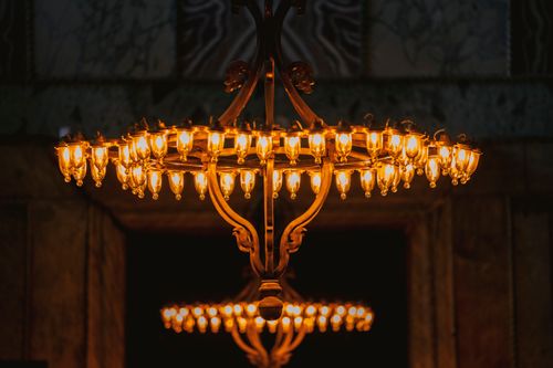 Free Close-up of an elegant chandelier illuminating a historic interior with warm lighting. Stock Photo