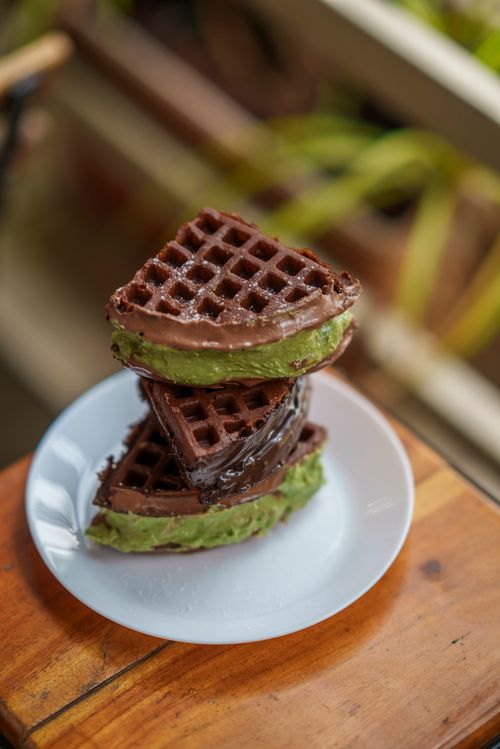 Free Stack of chocolate waffles with matcha filling served on a white plate. Stock Photo