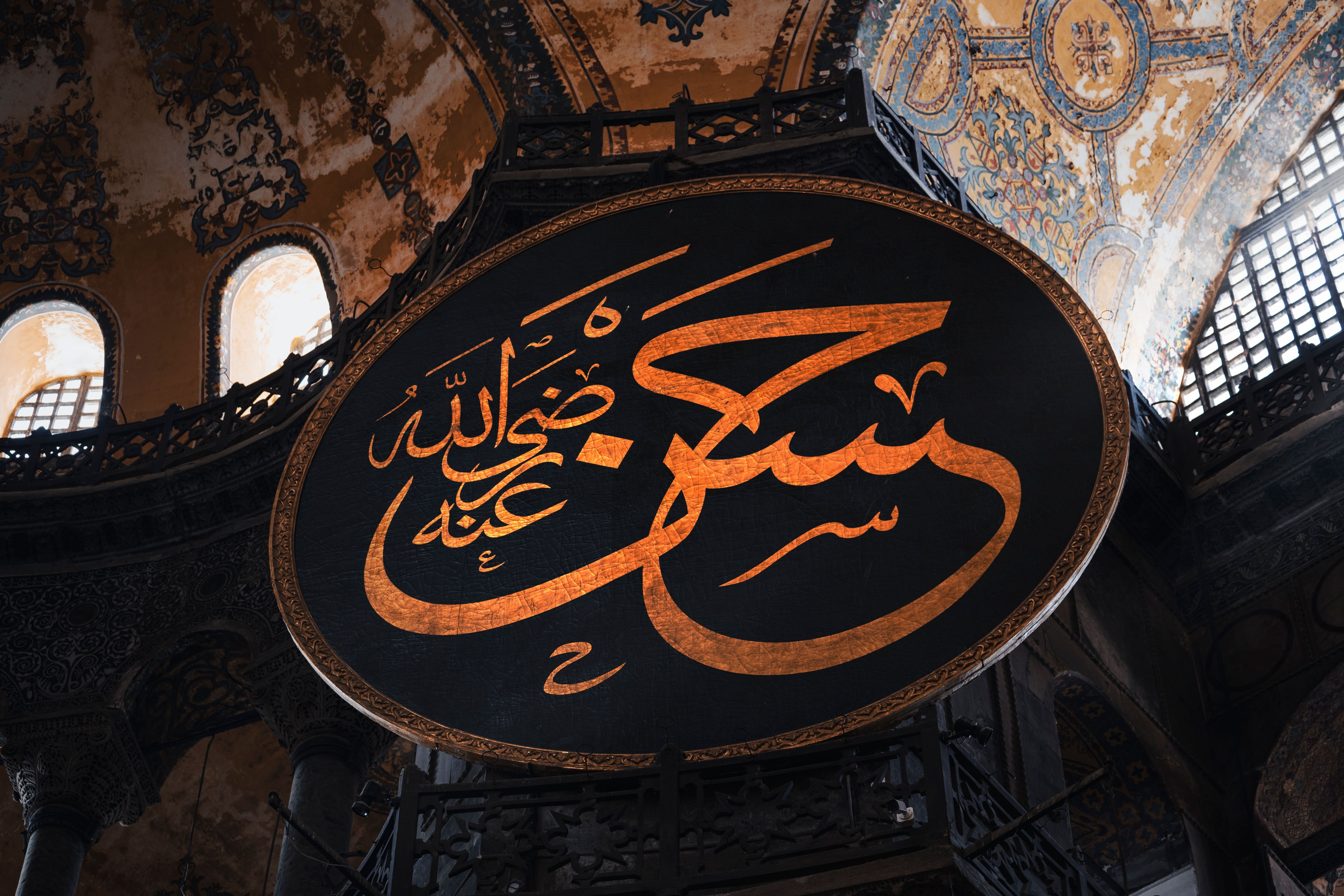 A close-up view of ornate Arabic calligraphy in Istanbul's historic Hagia Sophia, showcasing Islamic architecture.