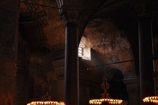 Sunlight beams illuminate the historic interior of Hagia Sophia, showcasing its ornate architecture.