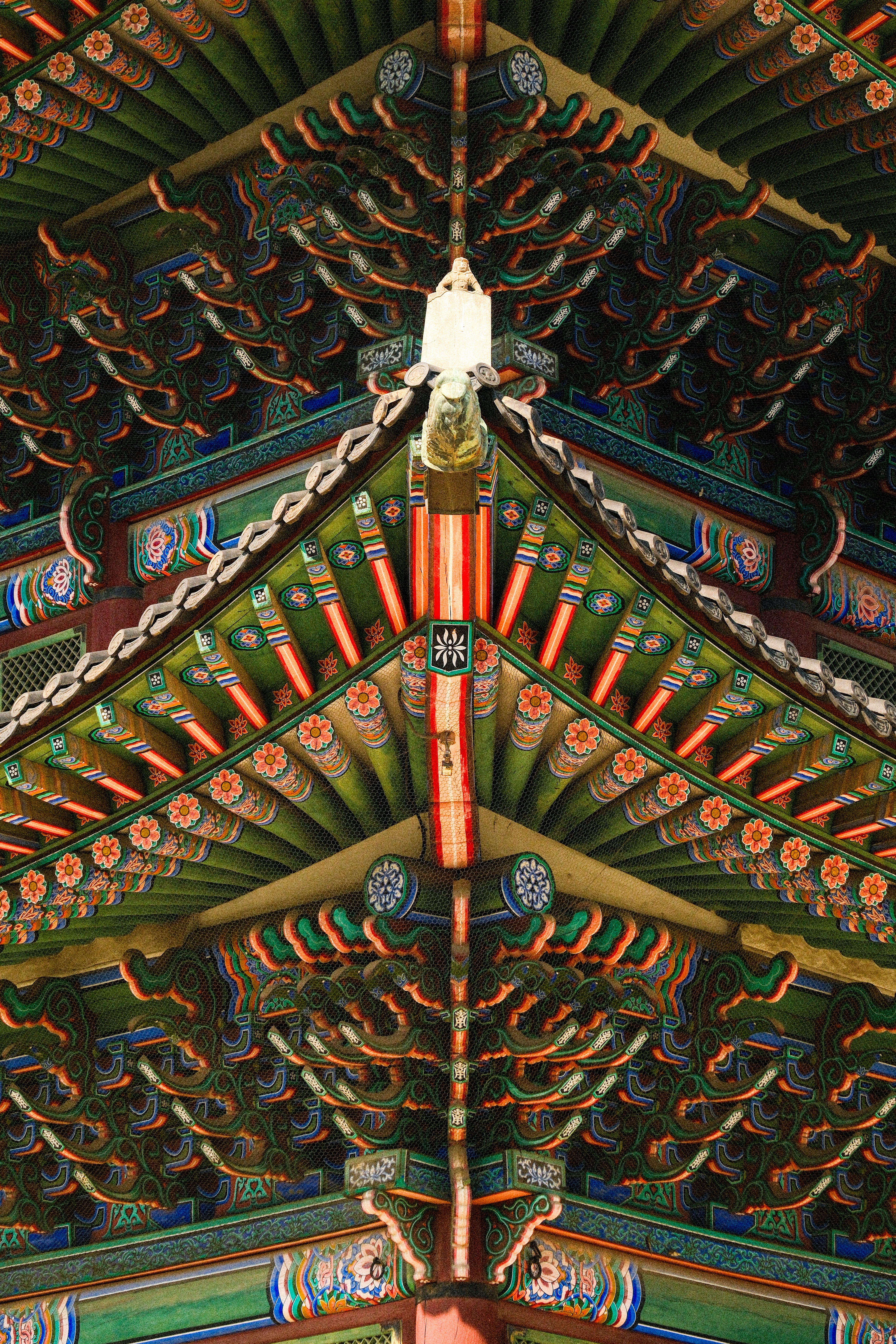 Detailed view of a colorful and ornate traditional Asian temple roof with intricate patterns.