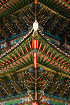 Detailed view of a colorful and ornate traditional Asian temple roof with intricate patterns.