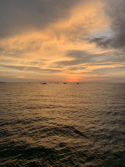 Free A tranquil sunset over the Caribbean Sea with a vibrant, colorful sky and calm waters, perfect for relaxation. Stock Photo