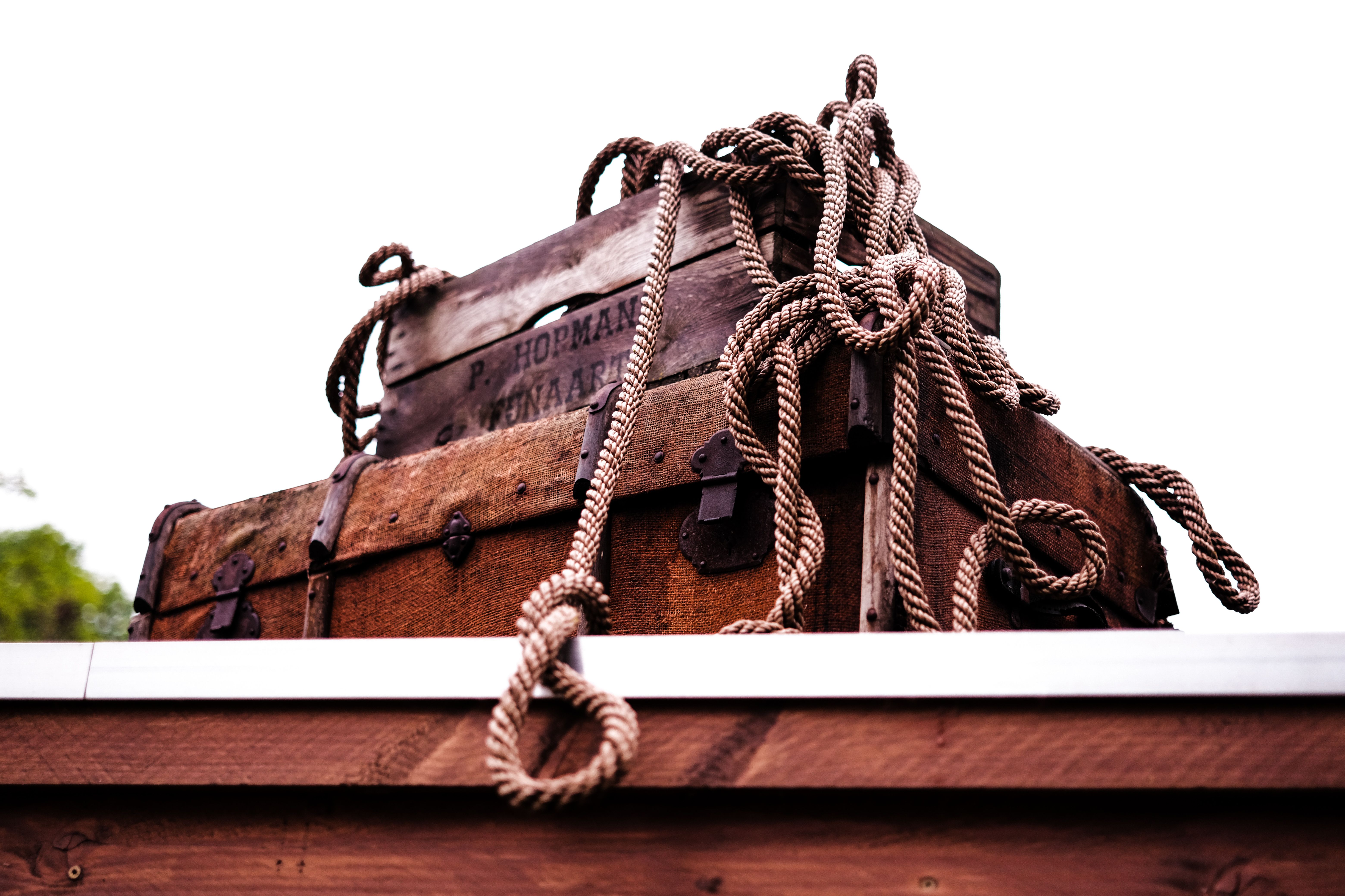 A rustic wooden chest entwined with nautical ropes on a wooden surface, conveying adventure.