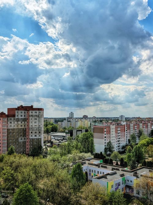 Free Aerial cityscape of Minsk, Belarus showcasing tall residential buildings under dramatic cloudy skies. Stock Photo