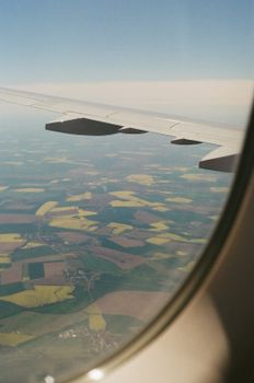 Scenic view of patchwork farmland from airplane flying high, showcasing landscape patterns.