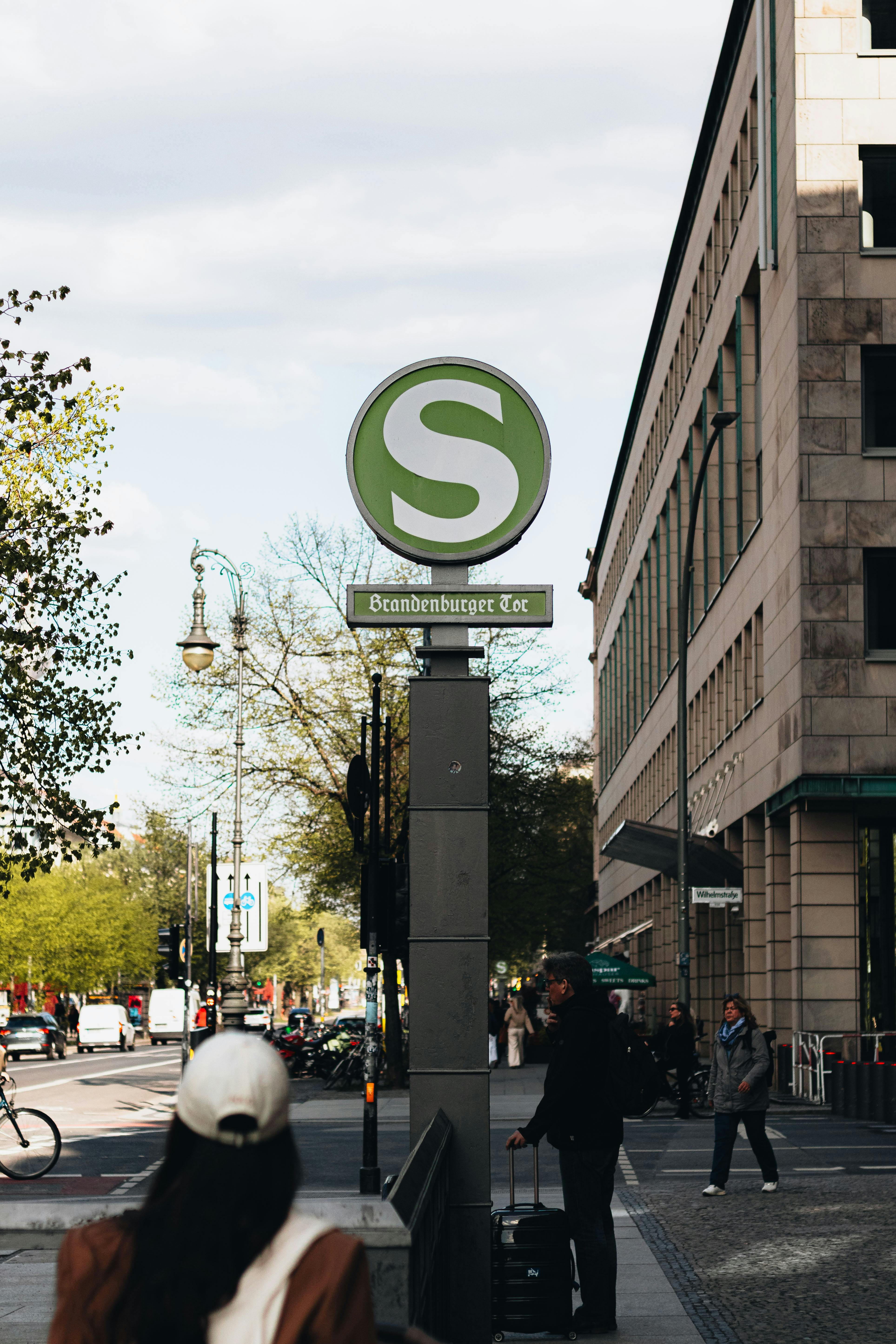 Urban scene featuring Brandenburger Tor S-Bahn sign with city life in Berlin, Germany.