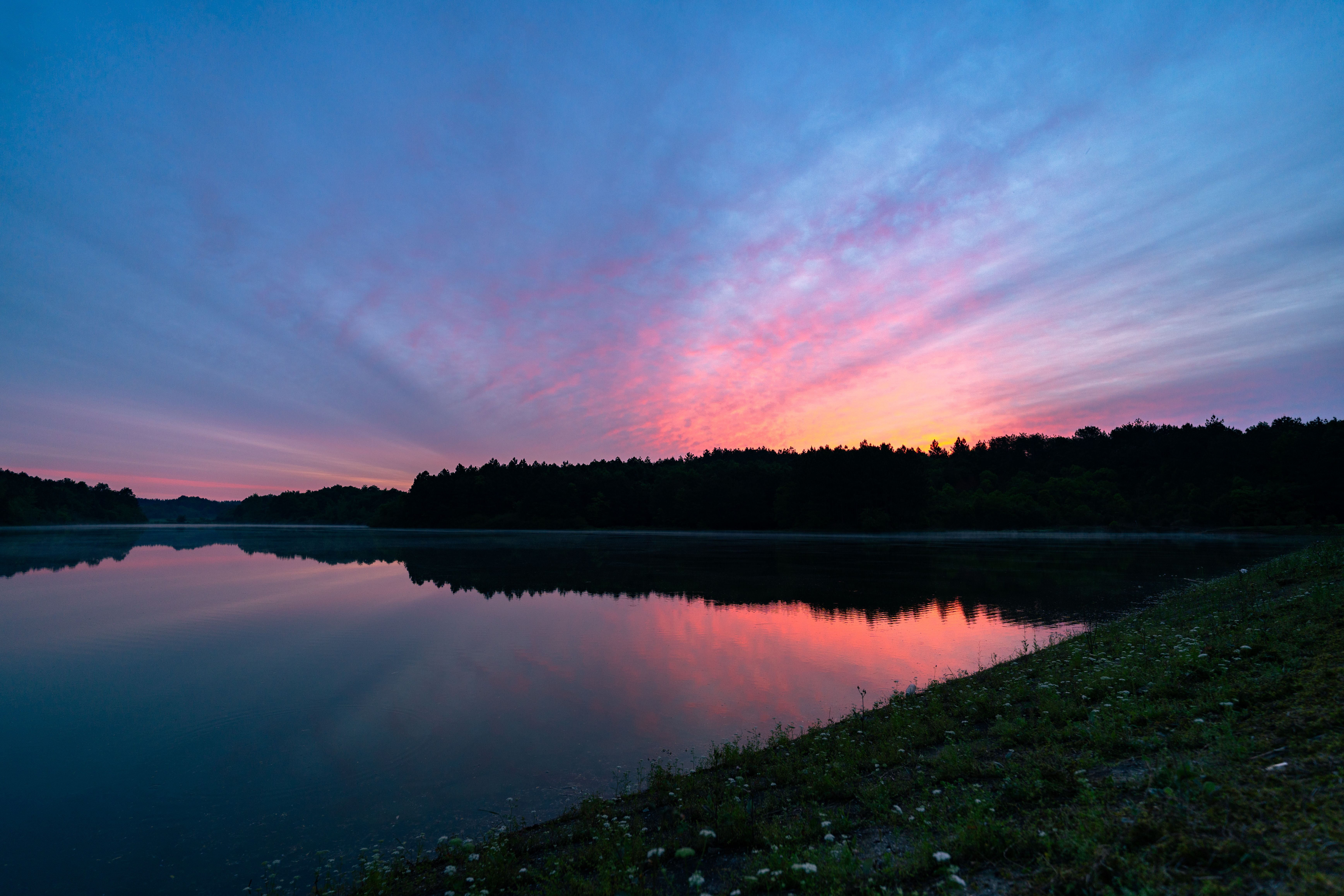 Serene Sunset Over Reflective Lake Landscape · Free Stock Photo