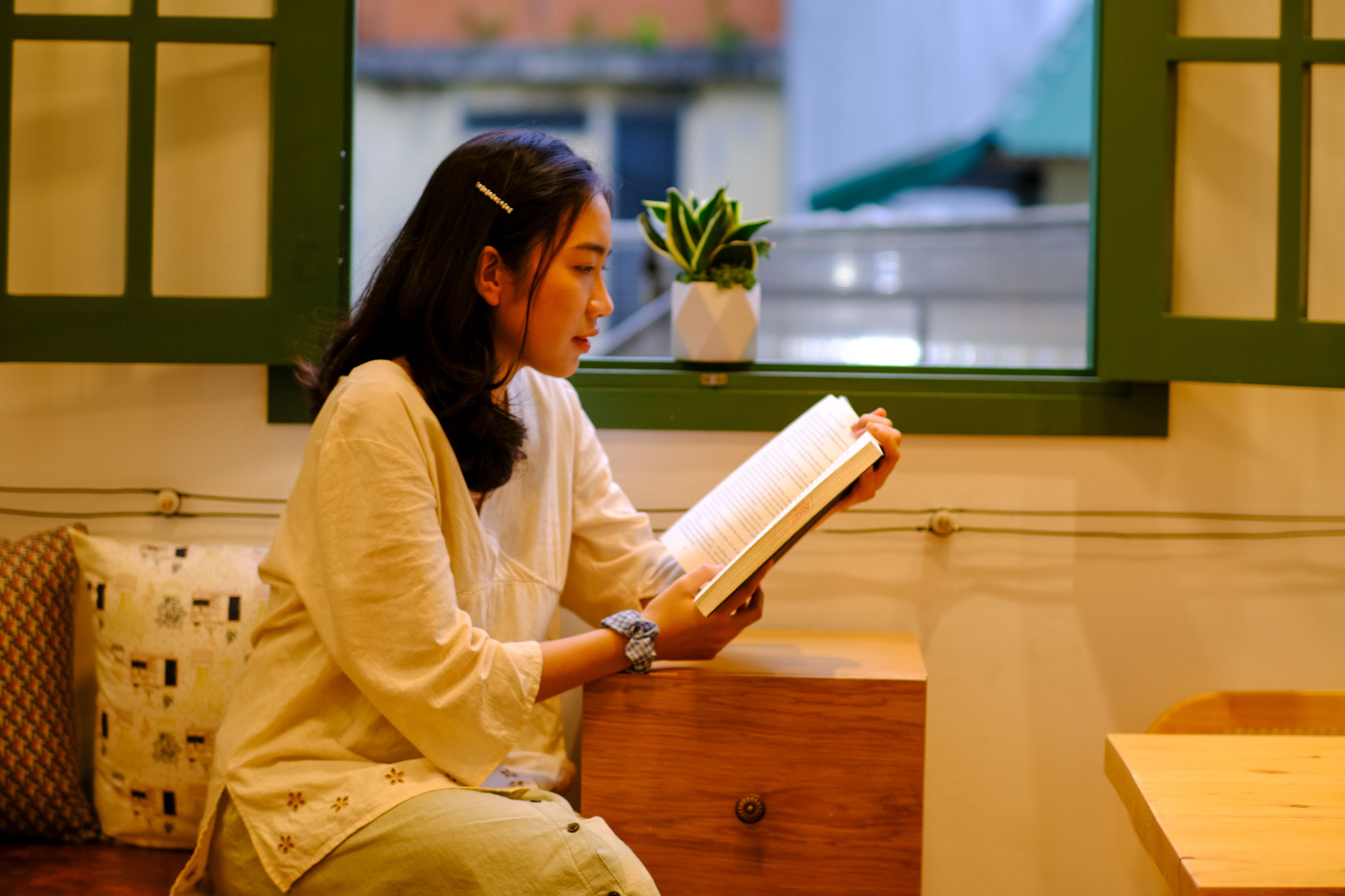 Young Woman Reading Indoors in Hue, Vietnam · Free Stock Photo