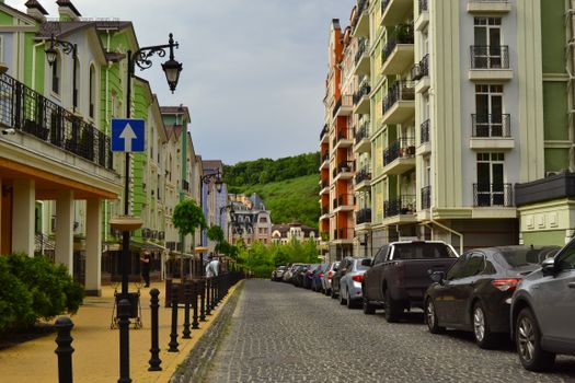 Charming European-style street with colorful architecture and parked cars.