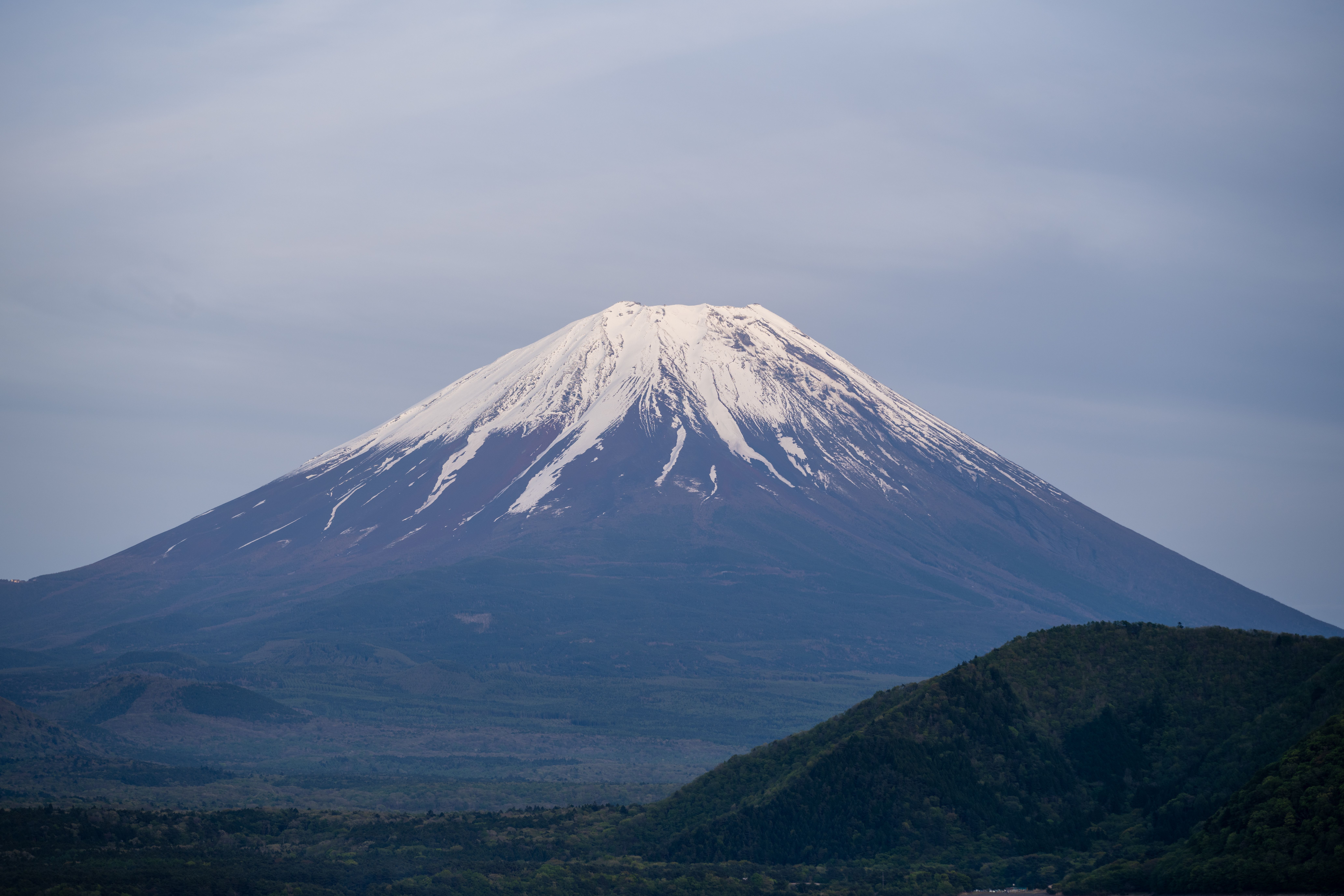 Snow-capped Mount Fuji under a clear blue sky.