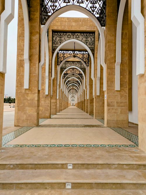 Free Stunning corridor of arches in Middle Eastern architecture, showcasing intricate and precise design. Stock Photo