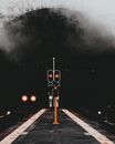 夜间拍摄的铁路隧道入口大气照片，红色信号灯和薄雾