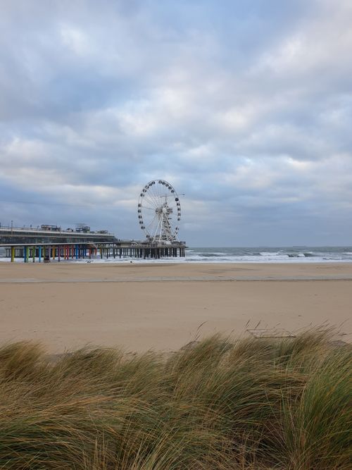 Free Capture of the iconic Ferris Wheel on a cloudy beach day at Scheveningen, Netherlands. Stock Photo