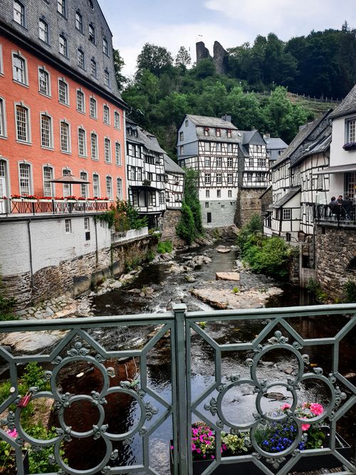 Free Picturesque European buildings by a river with lush greenery, showcasing historical architecture. Stock Photo