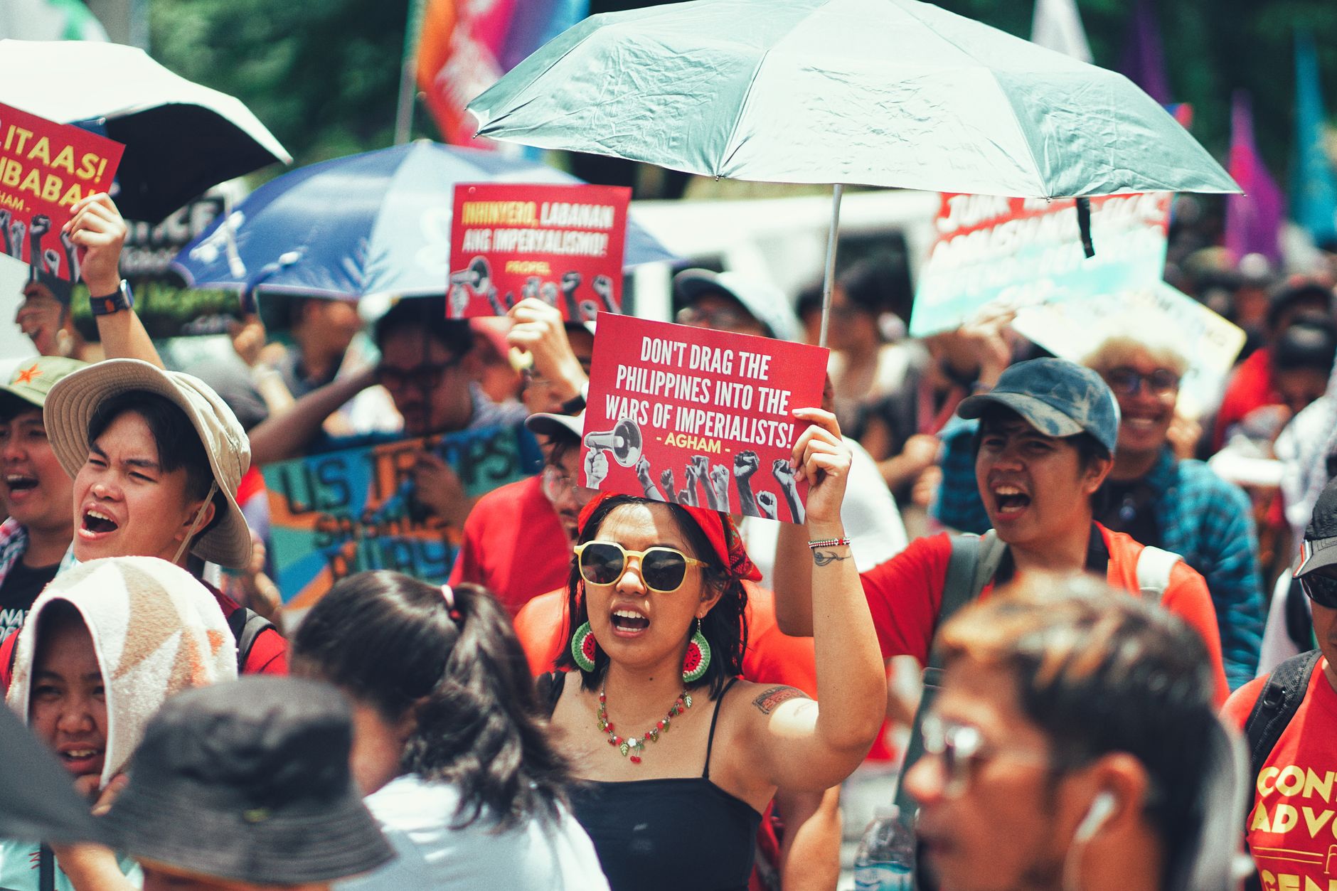 Crowd of protesters holding signs in a political demonstration outdoors.