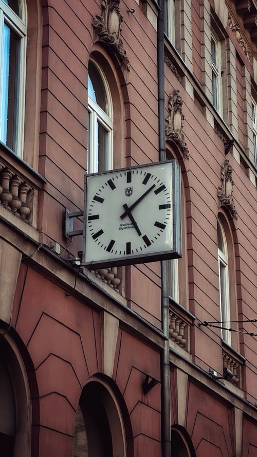 Free Square clock mounted on a historic building facade in Sarajevo, Bosnia and Herzegovina. Stock Photo