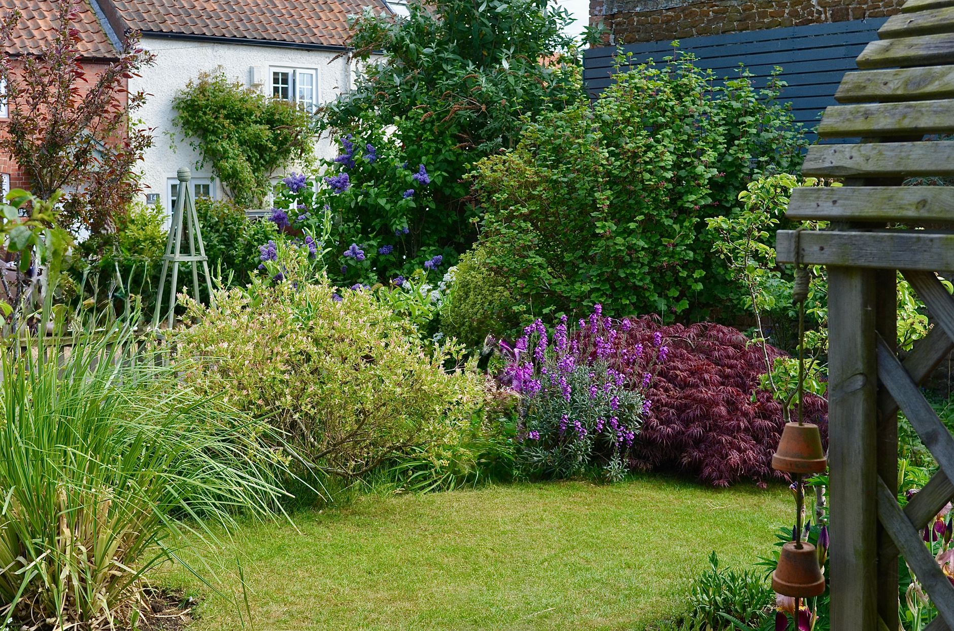 Lush English garden with colorful flowers and quaint cottage backdrop.