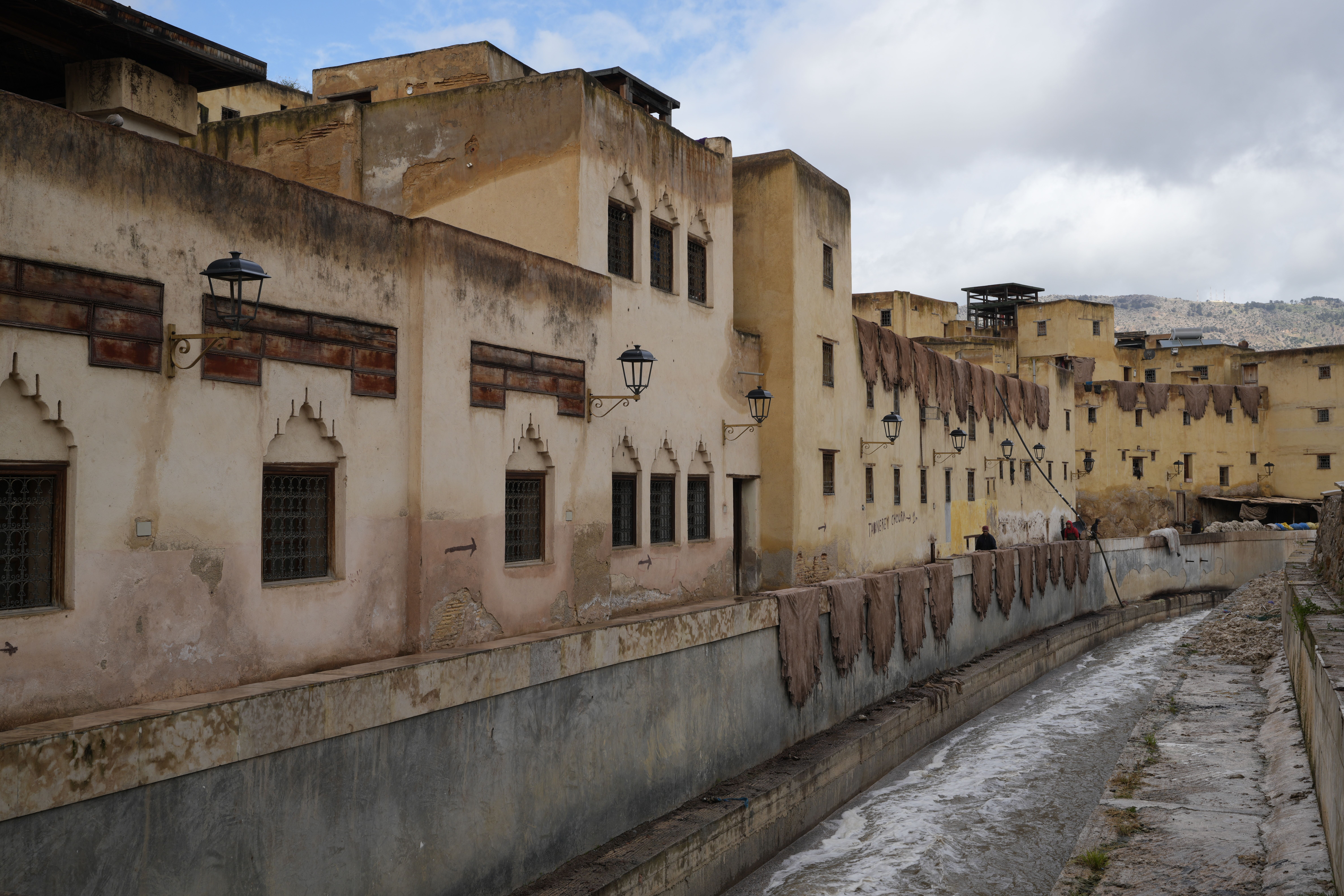 A view of the ancient tannery buildings along a narrow canal in Fez, Morocco.