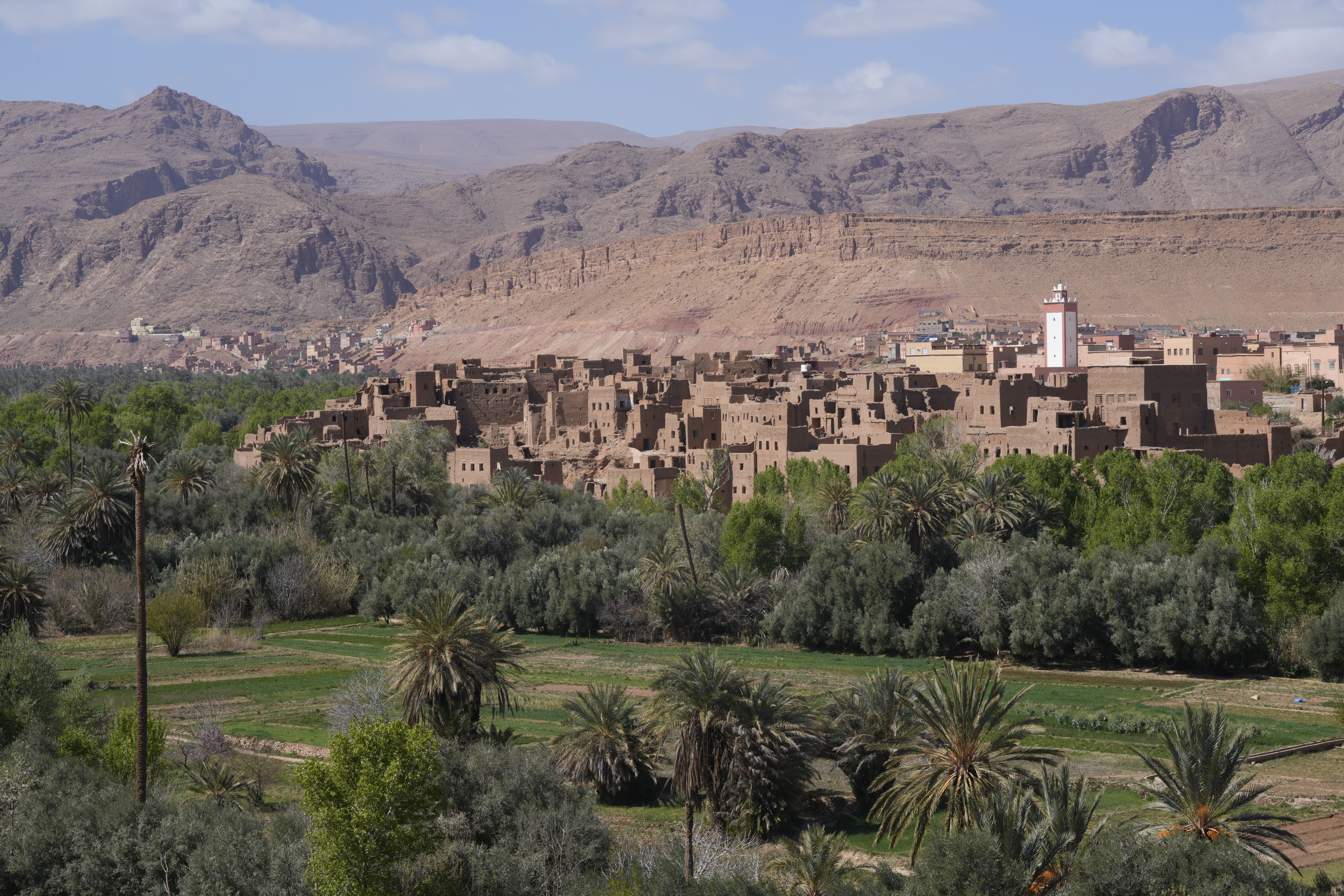 A stunning view of the Tinghir Oasis with traditional Moroccan architecture and arid mountains.