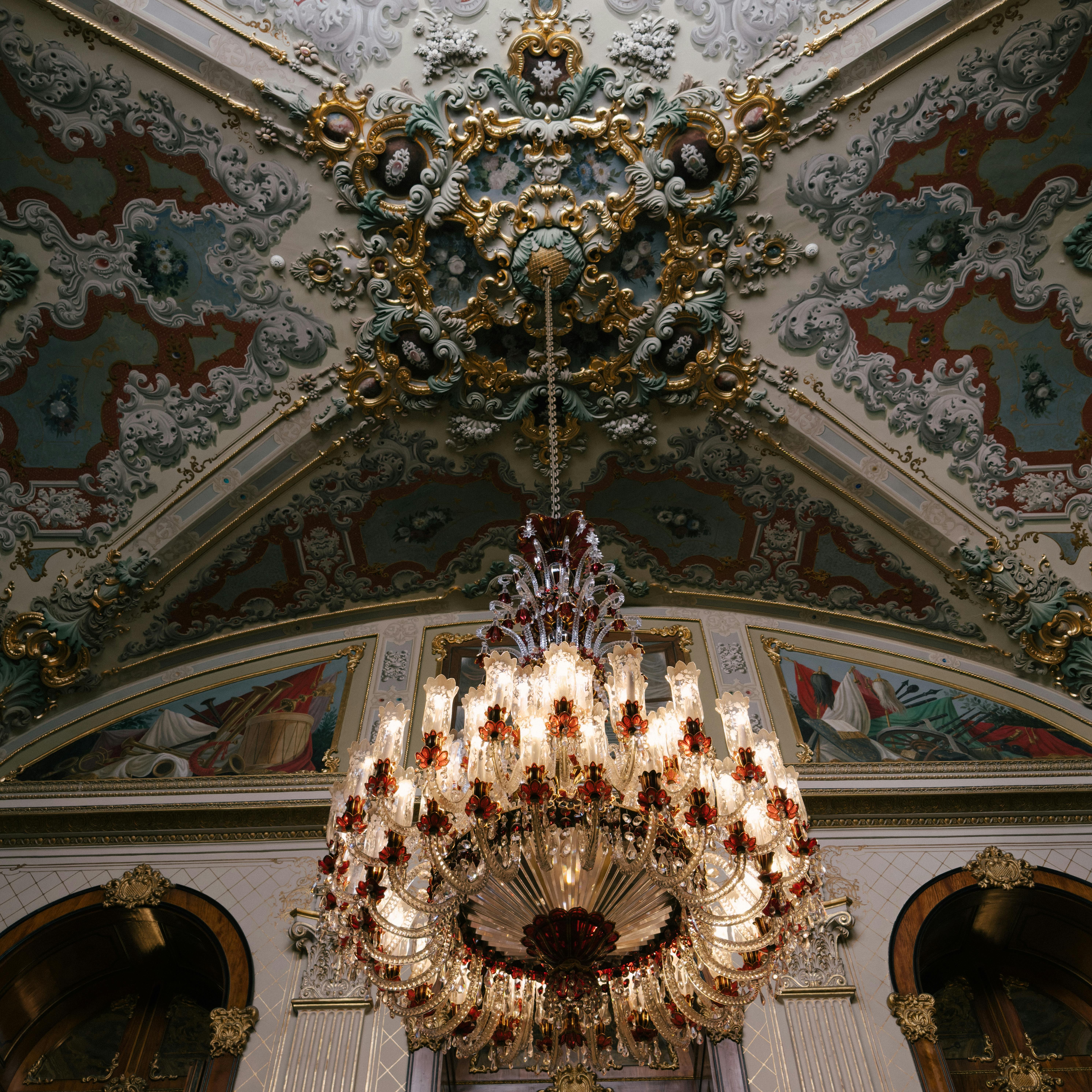 Opulent baroque ceiling featuring an exquisite crystal chandelier in a grand hall.