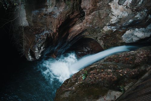 Free A breathtaking waterfall cascading through rocky terrain, showcasing nature's beauty and power. Stock Photo