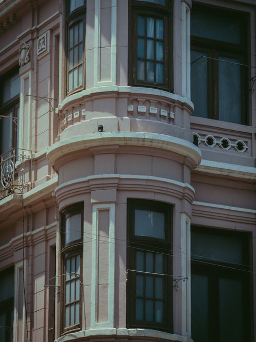 Free Close-up of a pink historic building facade with ornate windows in Puebla, Mexico. Stock Photo