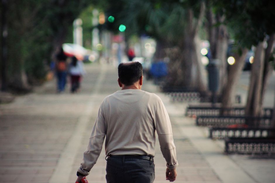 man walking away suburban street