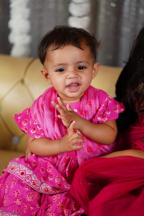 Cute baby girl in pink dress smiling indoors · Free Stock Photo