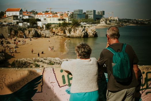 Senior couple enjoying a scenic view of Cascais beach in Portugal. Perfect representation of travel and relaxation.
