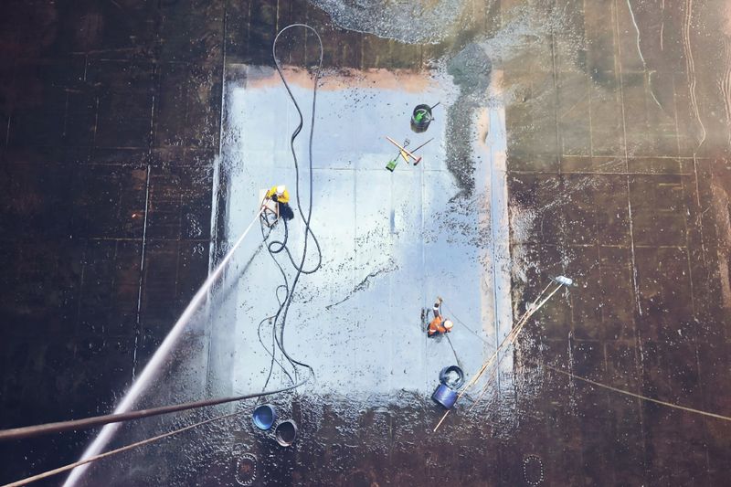 Medewerkers reinigen grote industriële vloer