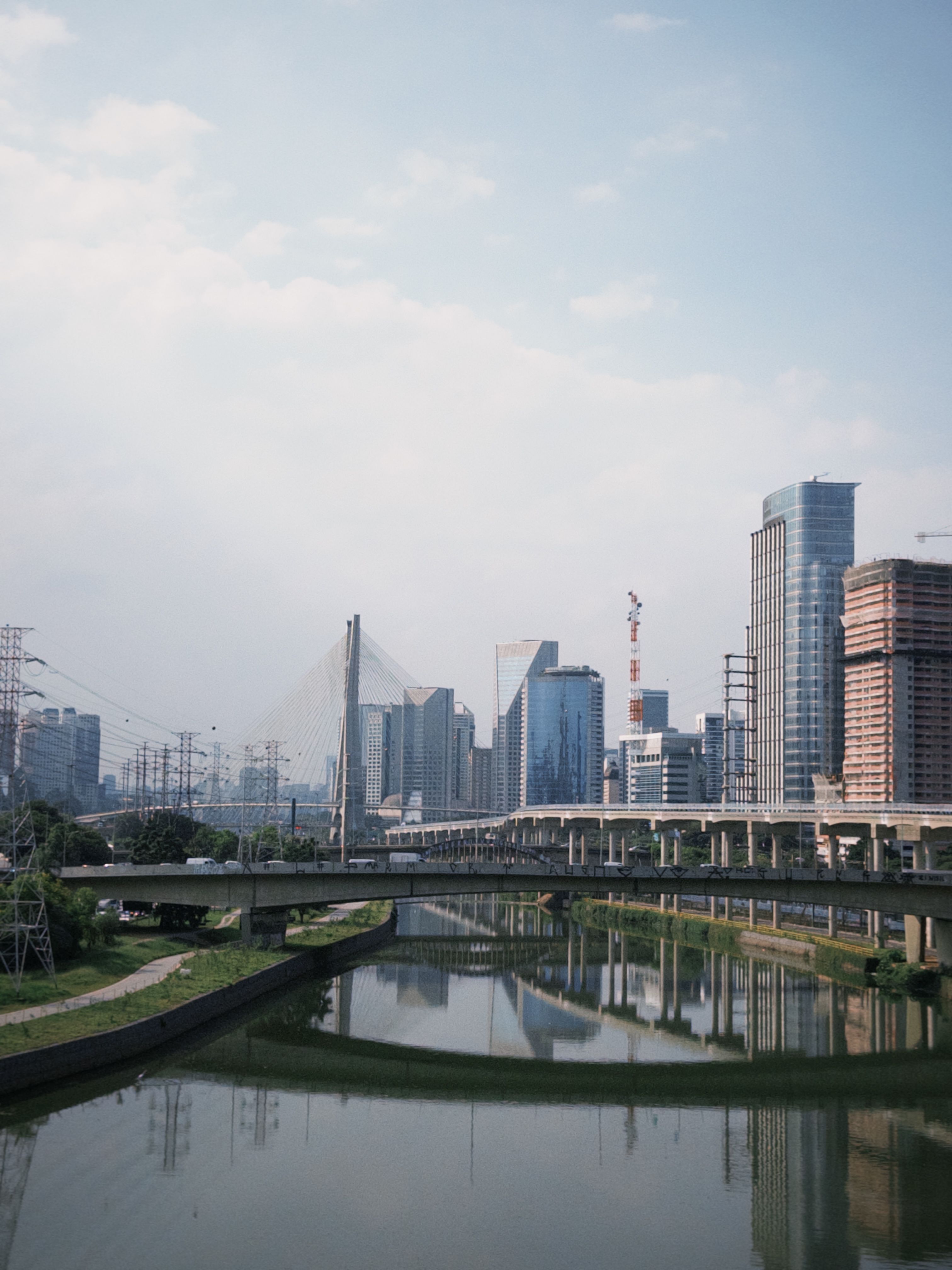 Scenic view of São Paulo's skyline with the iconic Octavio Frias Bridge reflecting over the river.