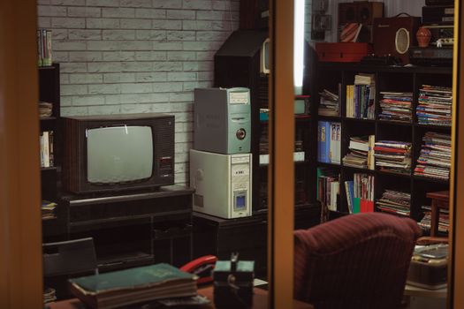 Cozy vintage room featuring retro television, bookshelves, and nostalgic decor.