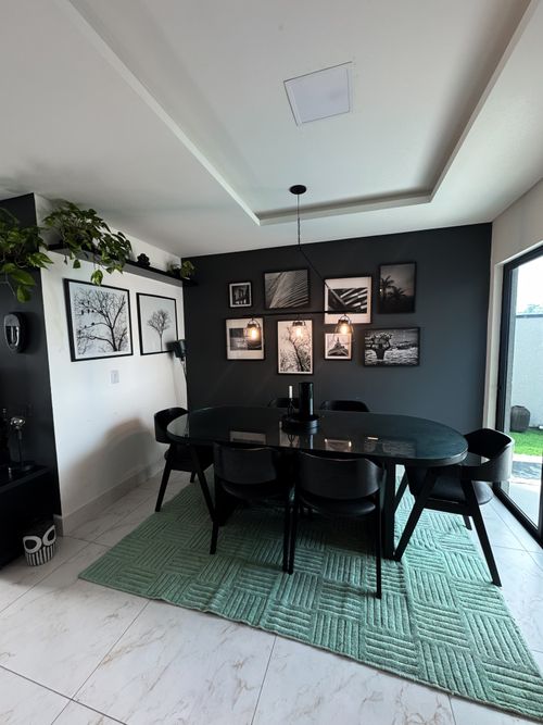 Free Elegant dining area with black chairs and monochrome wall art. Stock Photo