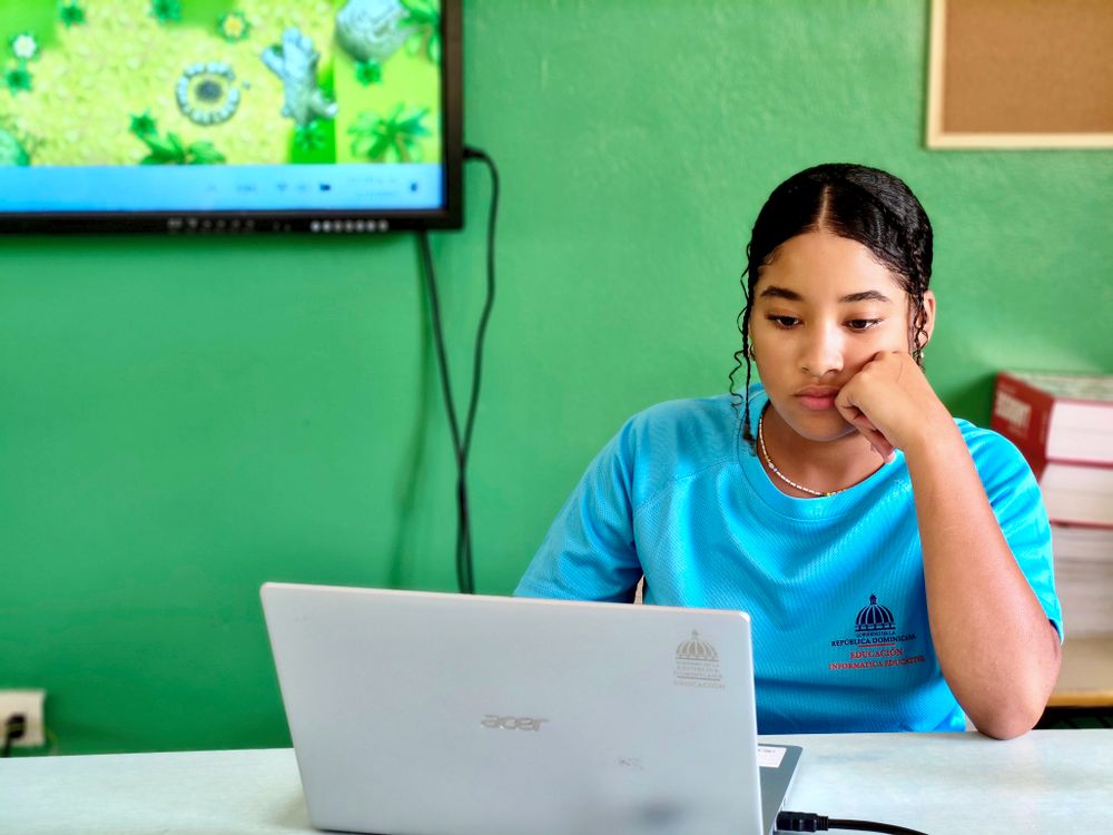 Jovem estudando com laptop e livros em casa