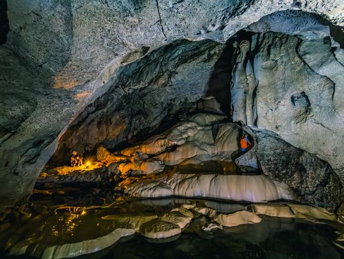 Free Explore a mesmerizing cave with illuminated stalactites and flowing formations inside. Stock Photo